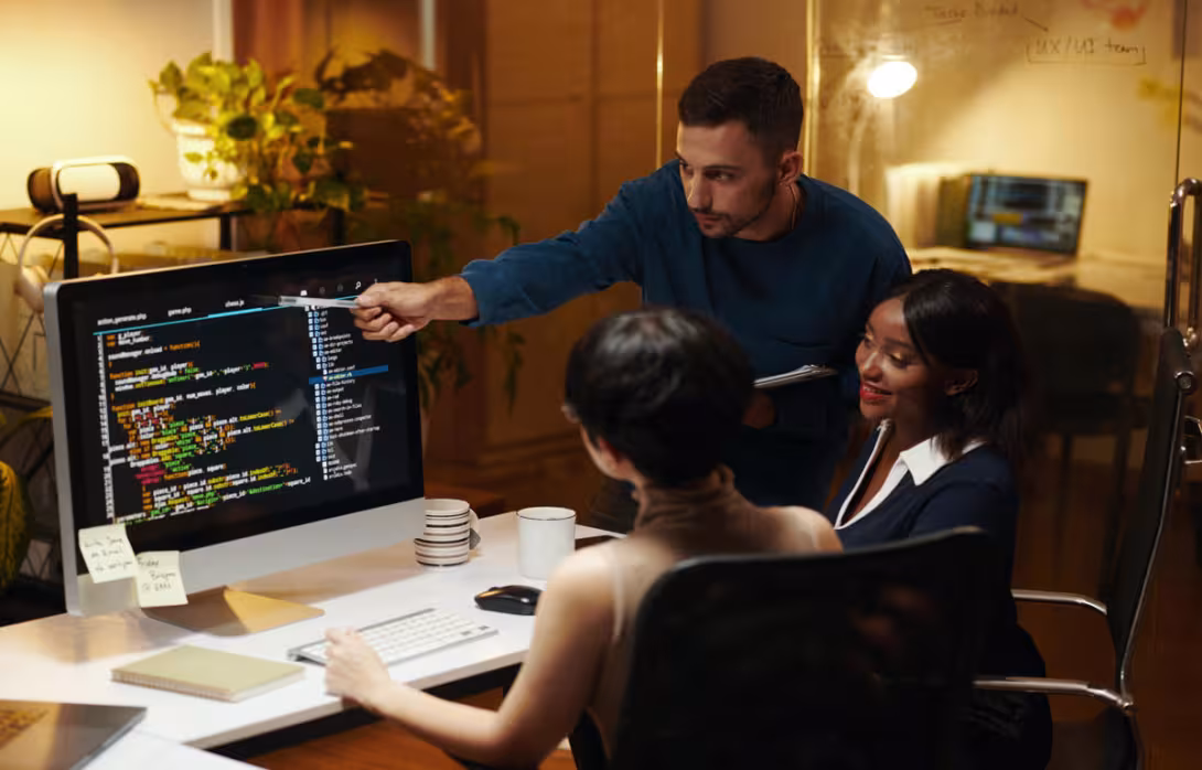 A developer points out important code details while teammates listen and engage in discussion. The moment reflects the collaborative spirit that makes software development both effective and inspiring.